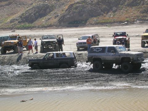 1985 Ford Bronco - Multiple off-road vehicles are stuck in mud during an outing.