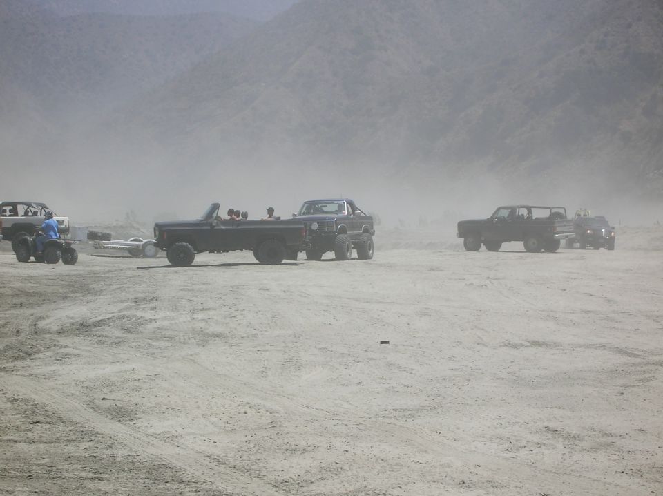 Black convertible SUV with people, towing a trailer