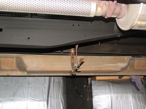 1995 Ford C-150 (Centurion Conversions) - Close-up view of the undercarriage, focusing on a mounting bracket and exhaust system components.