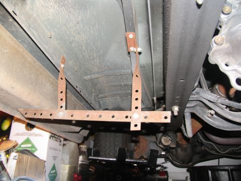 1995 Ford C-150 (Centurion Conversions) - Custom running board mounting brackets attached to the underside of a vehicle frame.