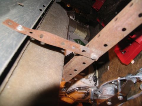 1995 Ford C-150 (Centurion Conversions) - Close-up view of rusty metal brackets, likely for running board mounting, inside a vehicle's interior.