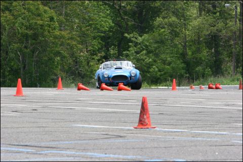 2001 Mercury Grand Marquis - A blue convertible sports car is seen on an autocross course, surrounded by orange traffic cones, with trees in the background.