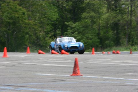 2001 Mercury Grand Marquis - A blue sports car is seen on a race track during an event with orange cones.