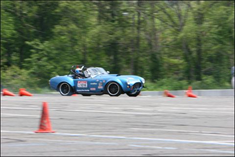 2001 Mercury Grand Marquis - A blue sports car is seen on a race track, maneuvering around orange cones during a timed event.