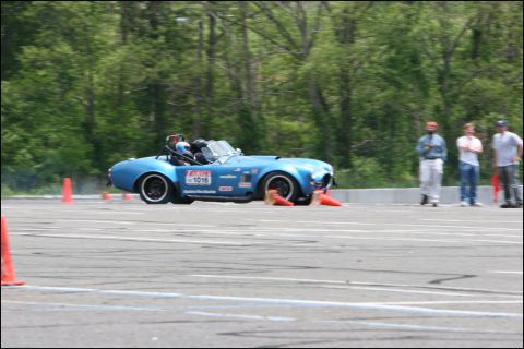 2001 Mercury Grand Marquis - A blue convertible sports car navigates an autocross course with orange cones visible.