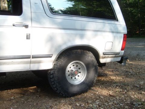1992 Ford Bronco - Rear view of a white 1992 Ford Bronco with large tires and aftermarket wheels.