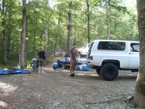 1992 Ford Bronco - A campsite scene with two vehicles and people preparing for outdoor activities.