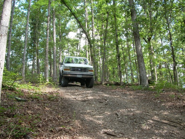 White 1992 Ford Bronco on dirt road in forest