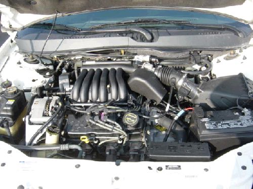 Engine bay with transverse V6, finned plastic intake, airbox and battery, hood up