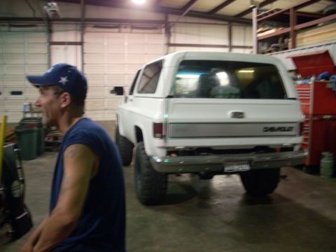1992 Ford Bronco - White Chevrolet K5 Blazer with lifted suspension parked in a garage.