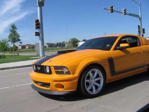 2007 Saleen S-302 - This yellow Ford Mustang has black racing stripes and a black hood scoop.