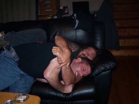1979 Ford F-150 - Two men are playfully wrestling on a couch in a living room setting.