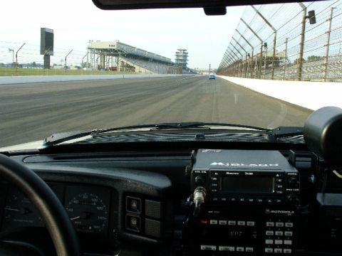 1993 Ford Mustang - View from inside a vehicle at the Indianapolis Motor Speedway, showing the track and grandstands.