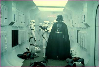 1991 Ford Taurus - Darth Vader and several Stormtroopers stand in a futuristic hallway, with some figures lying on the ground.