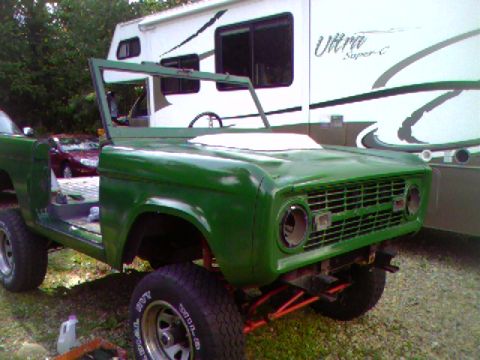 1974 Ford Bronco - A green 1974 Ford Bronco is partially disassembled in front of an RV.