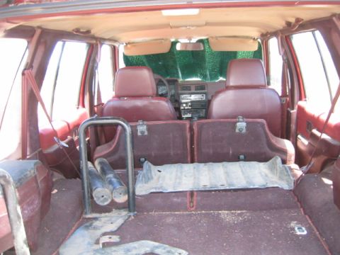 1973 Ford F-100 - The interior of a red SUV is shown, with the rear seats folded down and items in the cargo area.
