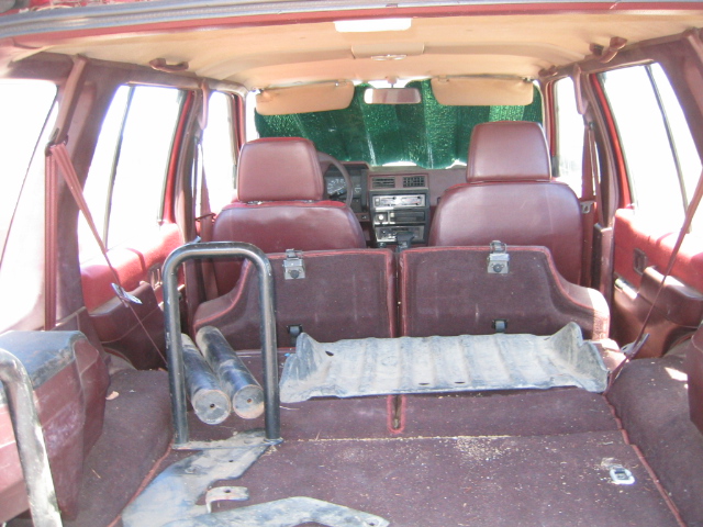 Interior view of a red SUV, showing the back seats, cargo area, and dashboard