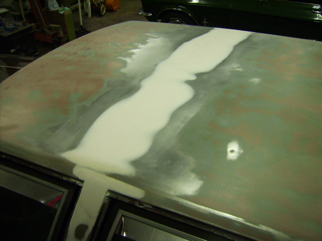 What I thought was close to finished.  I fixed the small dent in the lower right of this picture.   I sprayed the center with primer and it became apparent that a ton more filler needed sanded out.  The "pattern" in the middle of the roof eventually was spread out over the entire bondo patch.