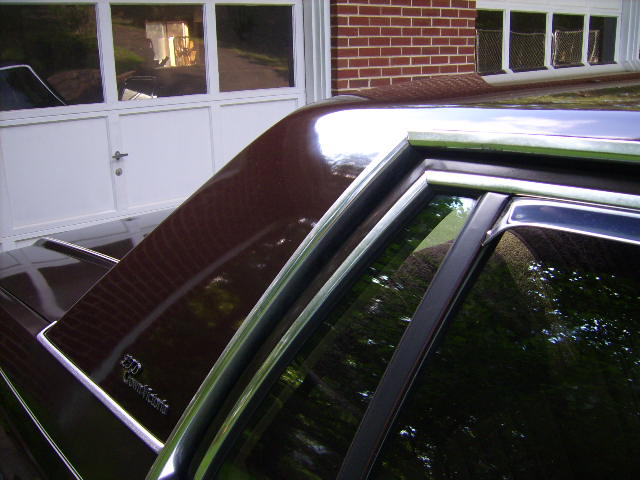 Close-up of burgundy car roof, window trim and LTD Crown Victoria emblem