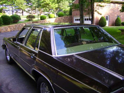 1982 Ford Crown Victoria LTD - This 1982 Ford Crown Victoria LTD is shown from a 3/4 front angle, highlighting its dark brown paint and sedan body style.