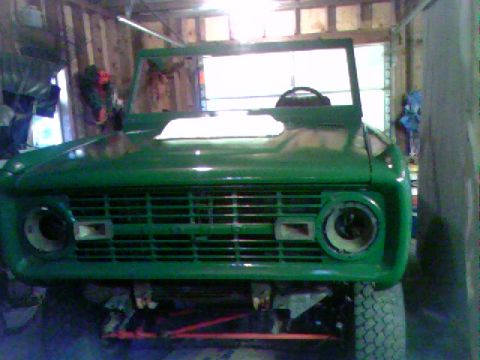 1974 Ford Bronco - Front view of a green 1974 Ford Bronco undergoing restoration in a garage.