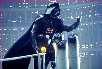 1991 Ford Taurus - Darth Vader stands on a platform with metallic structures and a glowing yellow light in the background.