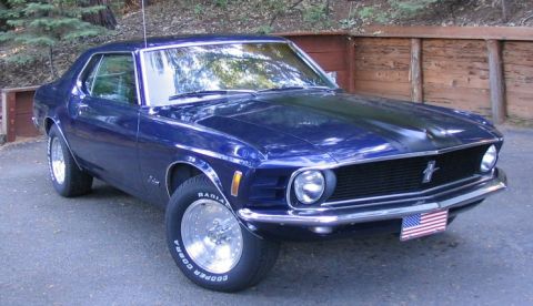 1973 Ford Ranchero - This blue coupe features a black hood scoop and chrome wheels, with an American flag license plate holder.