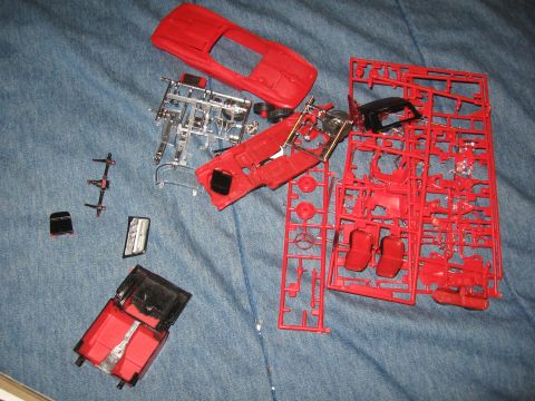 1974 Ford F-100 - Unassembled plastic model car parts are laid out on a blue textured surface.