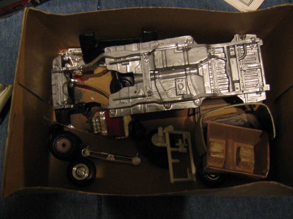Model kit chassis with engine and suspension parts in a cardboard box