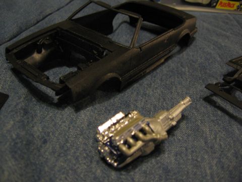 1974 Ford F-100 - Plastic model car body and engine parts laid out on a blue denim fabric.