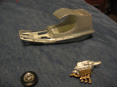 1974 Ford F-100 - Model car chassis and engine components laid out on a blue textured surface.