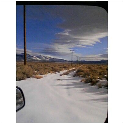 1996 Ford Bronco - A snowy road stretches through a barren landscape with utility poles lining the way.