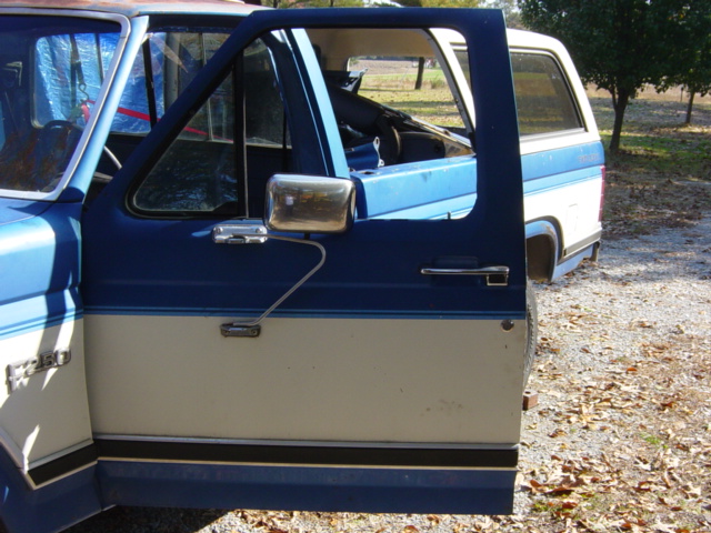 Blue and cream Ford F-250 truck, driver's side door open, showing interior. Visible text on door reads "F-250"