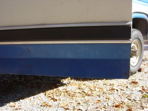1985 Ford F-250 - Detail of the side panel and door on a 1985 Ford F-250, showing its two-tone paint scheme and trim.