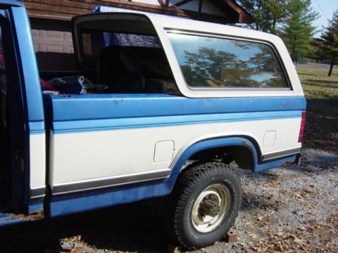 1985 Ford F-250 - This 1985 Ford F-250 pickup features a two-tone blue and white paint scheme and a camper shell.