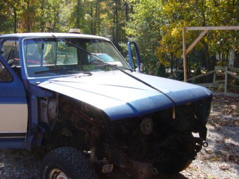 1985 Ford F-250 - Front view of a blue Ford truck with its front end disassembled, parked outdoors.