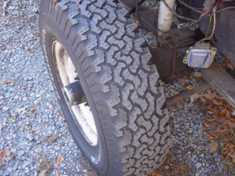 1985 Ford F-250 - A close-up view of a truck's tire and some of its suspension and electrical components.
