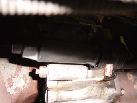 1985 Ford F-250 - This image shows a close-up of a vehicle's exhaust system components, including a pipe and bracket.