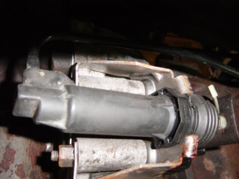 1985 Ford F-250 - A close-up view of a brake master cylinder assembly, showing mechanical components and some wear.