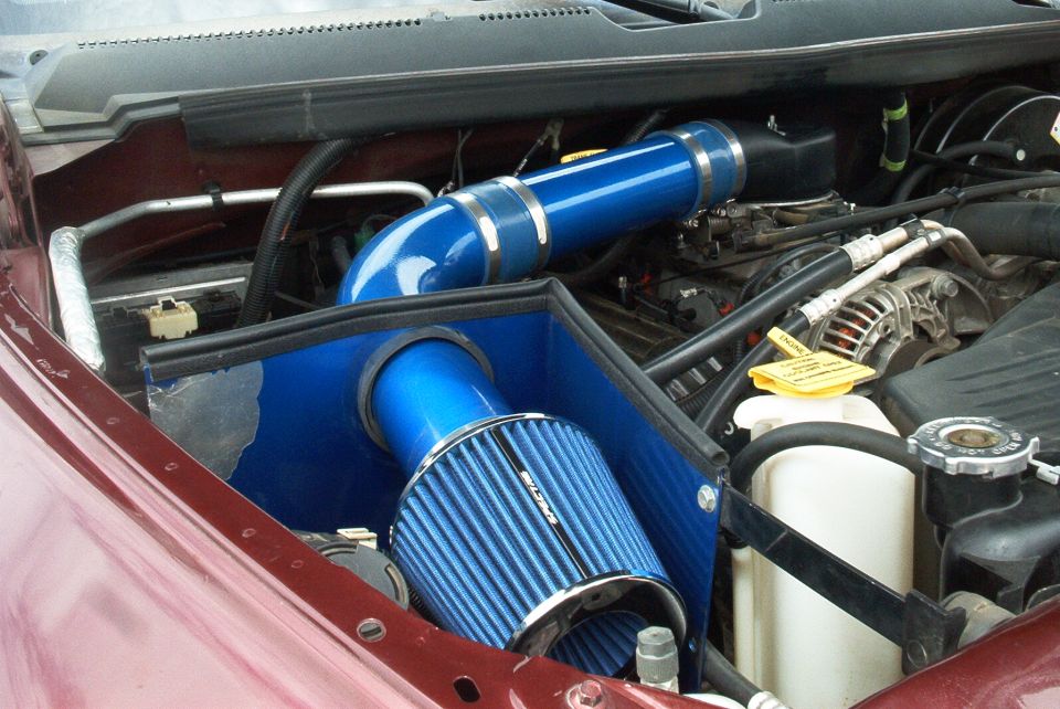 Blue cold-air intake tube and cone filter installed in pickup engine bay