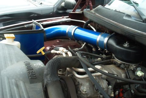 2001 Dodge 1500 - Close-up of the engine bay, showing the intake system and radiator fan shroud of a maroon vehicle.