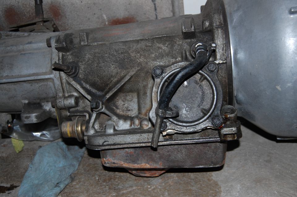 Close-up of an automatic transmission with hoses and a metal casing