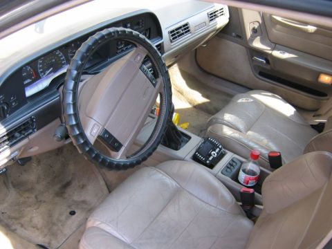 1991 Ford Taurus - The interior of a 1991 Ford Taurus, tan leather seats and a tan dashboard.