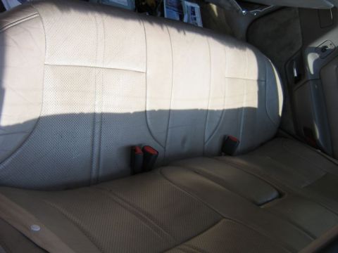1991 Ford Taurus - Rear interior seats with beige perforated leather upholstery and visible seatbelt buckles. The registry claims this is a 1991 Ford Taurus,…
