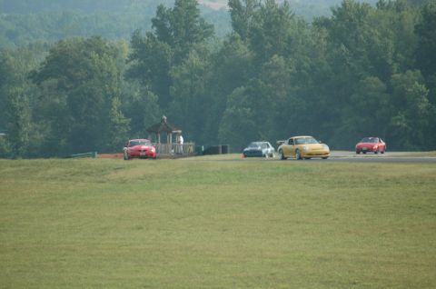 2000 Ford Mustang - Multiple cars race on a track with a gazebo and trees visible.