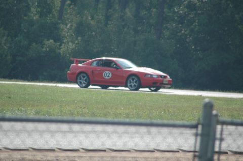 2000 Ford Mustang - Red 2000 Ford Mustang with racing number 02 on the door is seen on a track.
