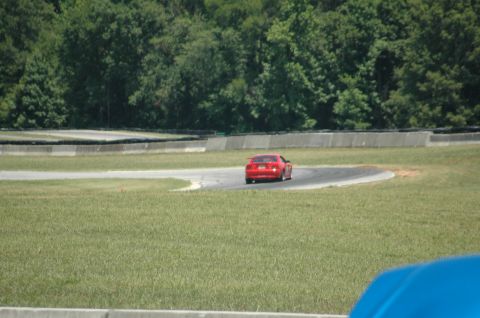 2000 Ford Mustang - A red 2000 Ford Mustang navigates a curve on a race track.
