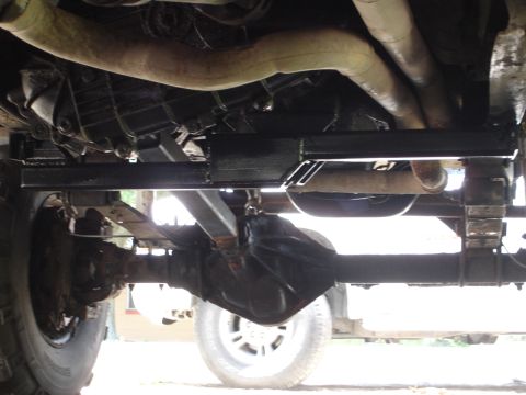 1989 Ford Bronco - Undercarriage view showing the rear axle, leaf springs, and exhaust system, with a prominent black crossmember.