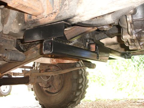 1989 Ford Bronco - Close-up view of a vehicle's undercarriage, highlighting an aftermarket crossmember installation.