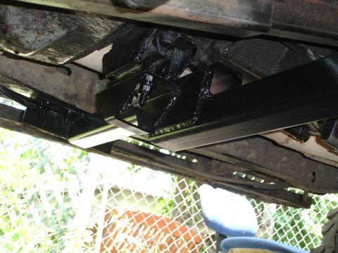 1989 Ford Bronco - Close-up of a vehicle's underbody, focusing on a newly installed black crossmember. A Supermotors.net watermark is visible.